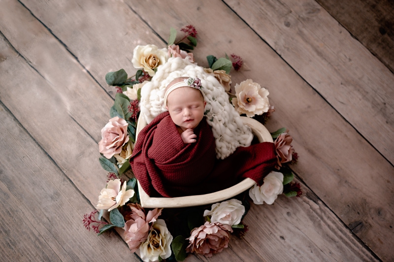 newborn girl in a heart prop with flowers. Morgantown newborn photographer