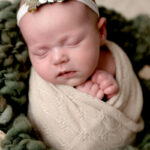 Newborn Girl wrapped in a lace cream wrap.
