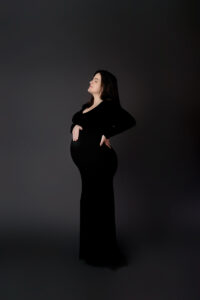 Maternity session in studio with mom wearing a black dress. Very elegant and stunning.
