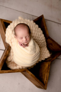 Newborn baby boy wearing yellow in a star
