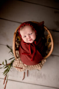 Newborn baby girl in a rattan chair. Newborn photography in Morgantown