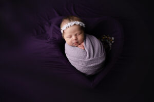newborn girl in a purple heart