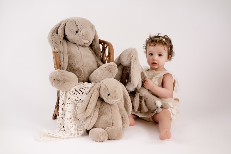 One year session with teddy bears and rattan chair. Boho style.