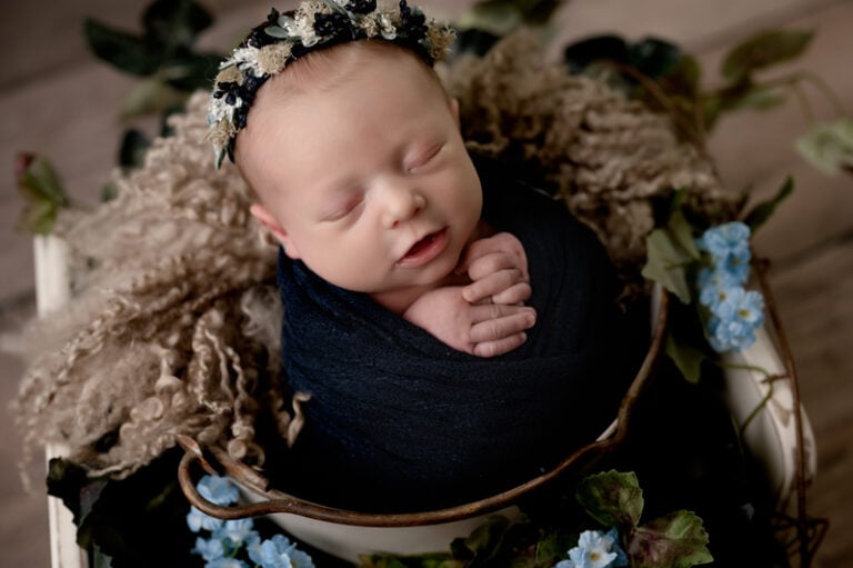 Newborn baby girl in a basket with flowers in the Morgantown photography studio