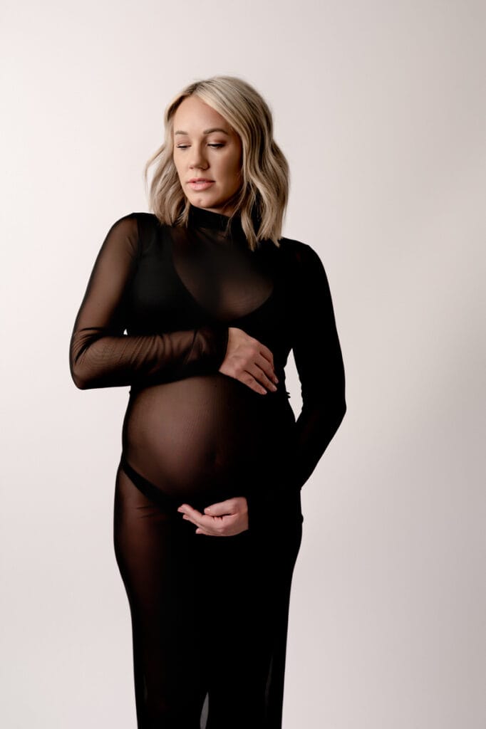 Modern maternity in the Morgantown photography studio. Mom is wearing a sheer black dress.