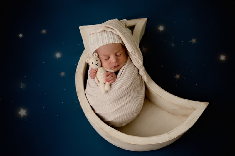 Newborn baby boy in a moon prop in the Morgantown, WV photography studio