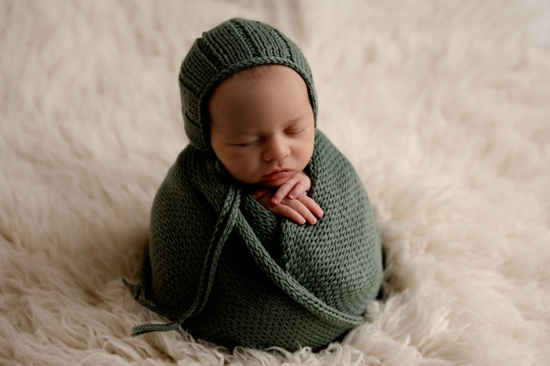 newborn baby boy in studio with sage green
