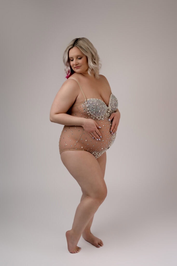 Maternity photoshoot in studio. Mom is wearing a jeweled bodysuit.