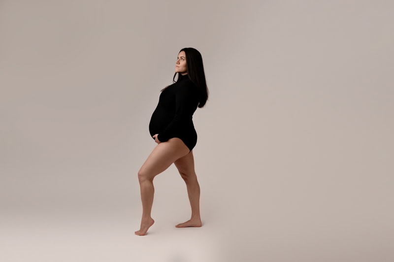Mom looks like a queen as she poses for her maternity session in a black bodysuit.