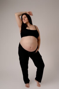 Maternity session with mom in black sports bra and black jeans